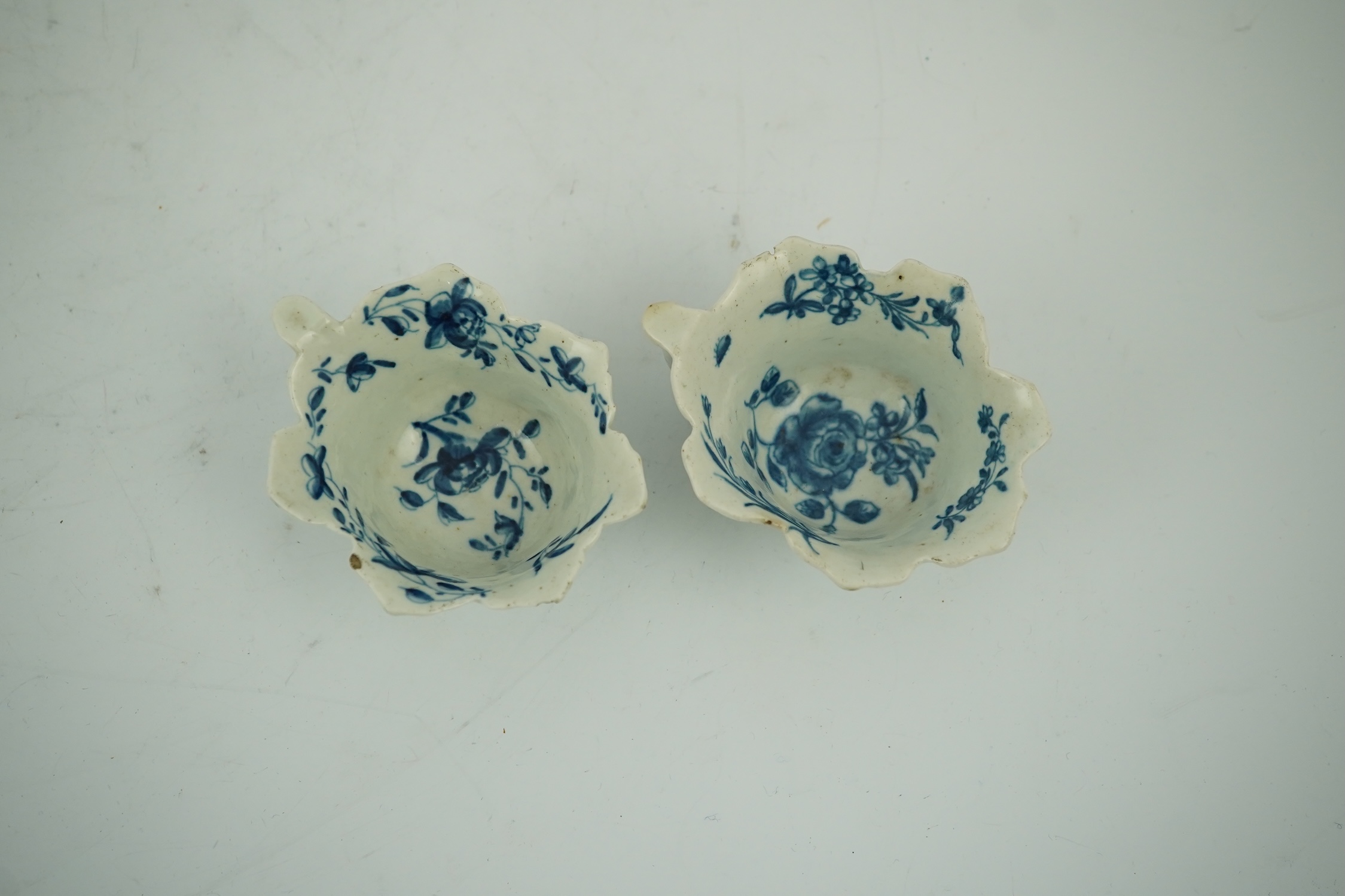 A pair of Worcester blue and white butterboats, c.1758-60, with differing blue and white decoration, 8cm wide. Condition - fair, some chips commensurate with age, one cracked.